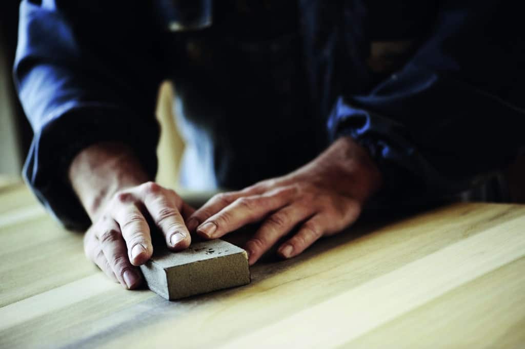 professional carpenter sanding and refinishing wood surface src parquet burgundy