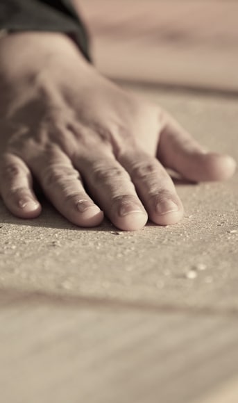 main qui touche une planche de bois